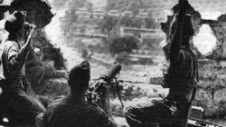 Indian troops, highly disciplined and trained, man a machine gun in a ruined building.